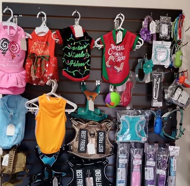 La foto muestra los vestidos, ropa, arnés para perros y gatos, bolsas para heces, deposito de bolsas