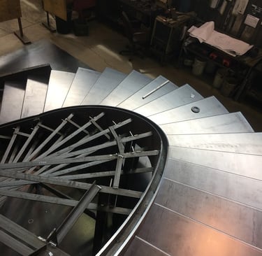 Metal eliptical stairs during installation, by Pengelly Iron Works