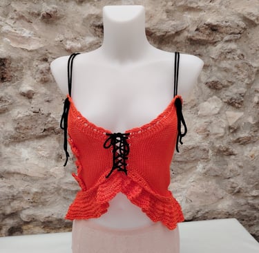 Caraco tricoté dans un fil coton orange avec des liens noir