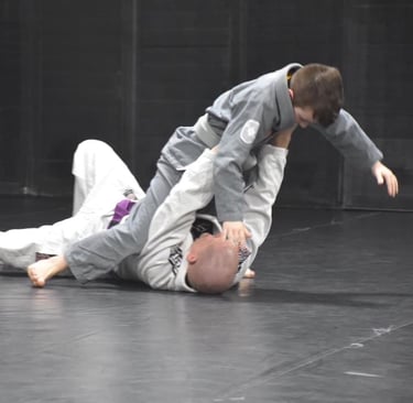 coach training child in bjj