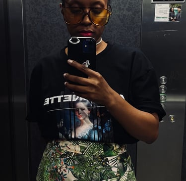 a woman in a black shirt and skirt with a phone