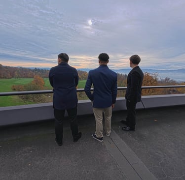 Three men standing on a balcony overlooking a landscape, symbolizing long-term vision and strategic 