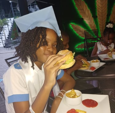 a girl in a graduation cap and gown is holding a burger