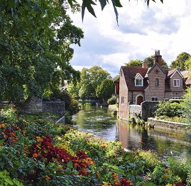 Maison en brique rouge sur les bord de la riviere Great Stour à Canterbury bordée de fleurs