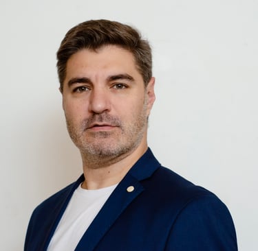 Consultor de marketing digital profesional con blazer azul, fondo blanco.