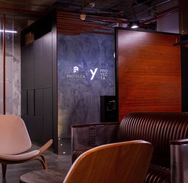 Muro en microcemento con logo retroiluminado - Protelca, Proyecta