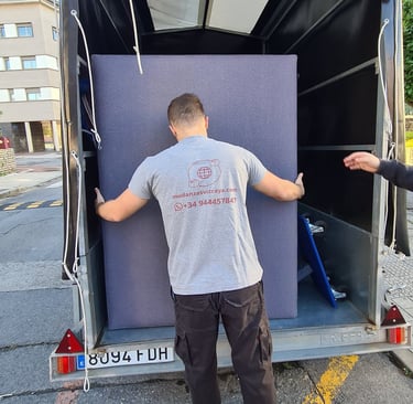 a man is moving a couch into a moving truck