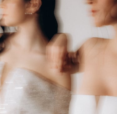 two women in white dresses standing next to each other