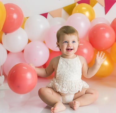 bebé sentada delante de globos en sesión de smash cake