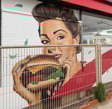 Mural de gran formato sobre fachada urbana realizado con aerosol. Representación figurativa que comb