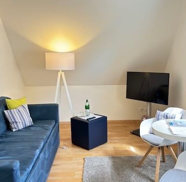 Hotel DunenNest - Kleine Suite, Wohnzimmer, Sofa, Sitzecke mit Tisch