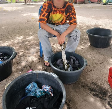 Photo d'un jeune accompagné par Bourokk et Kadiamor qui s'occupe de laver son linge à la main