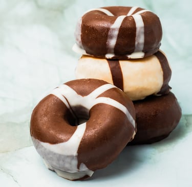a stack of chocolate covered donuts with chocolate frosting