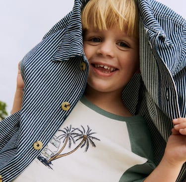 Wheat SS25 campaign imagery with a blond boy with a striped shacket over his head