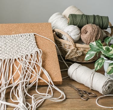 Proyecto de colgante de pared de macramé hecho a mano, fijado a un tablero de corcho.