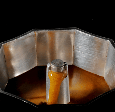 "Cafeteira italiana com a tampa aberta cheia de café fresco, ilustrando o preparo de café em Curitib