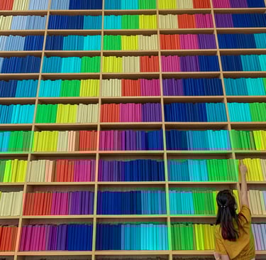 a woman standing in front of a large bookcase
