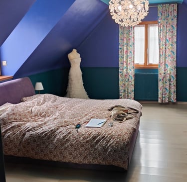 chambre avec lit 2 places murs vert et bleu, plafond bleu turquoise, luminaires rond à fleurs