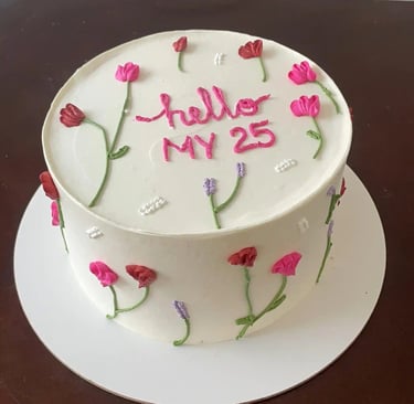 Bolo de aniversário decorado com flores coloridas, com a inscrição 'hello MY 25' em cima. Ideal para