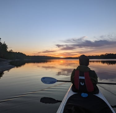 a person in a kayak paddling through the water (archipelago in Stockholm)