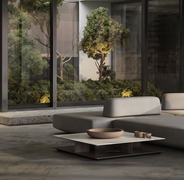 3D rendering of a modern indoor space with grey sectional sofa, low coffee table, glass panels, greenery, and natural light