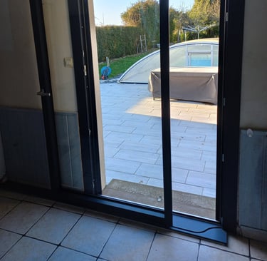 porte coulissante en pvc noire donnant sur jardin posée par l'artisan menuisier en Vendée
