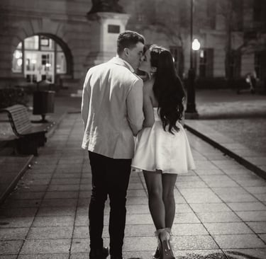 a couple kissing in a city street at night