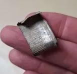 flattened antique silver thimble.