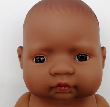 a Miniland baby doll with brown eyes