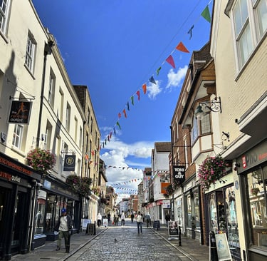 Rue pietonne pavée bordée de petits magasins 