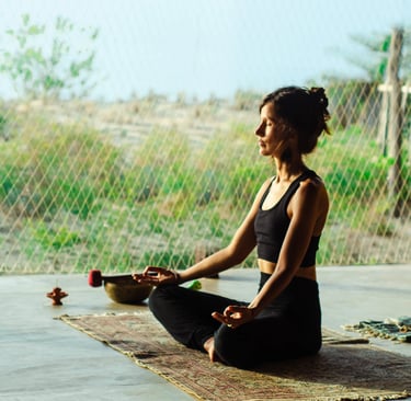 Isabel Maass meditating in yoga shala with afternoon sun, symbolizing demystifying meditation and mindful presence.