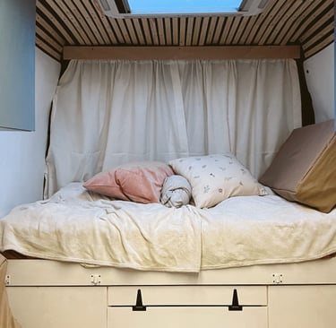 motorhome interior, a bed with some pillows on top