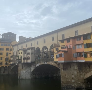 the ponte vecchio in Florence, Italy with medieval towers in the background