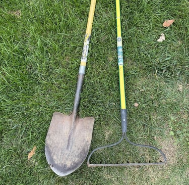 Well-used shovel and rake.