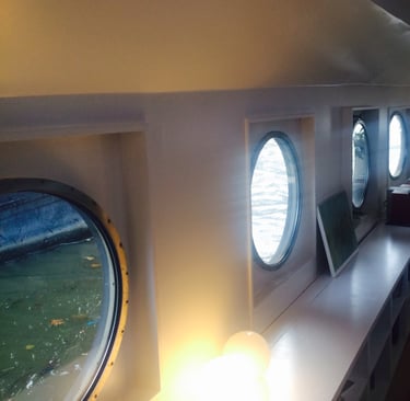 Patrijspoorten in de woonkamer van een woonboot