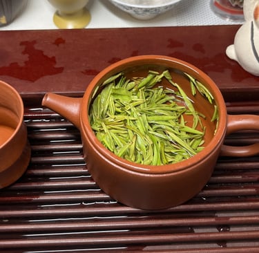 Tea set placed on a wooden tea tray, with green tea inside the teapot