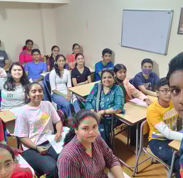 a group of people sitting at desks in a classroom