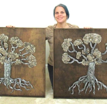 visual artist holding sculpture of trees