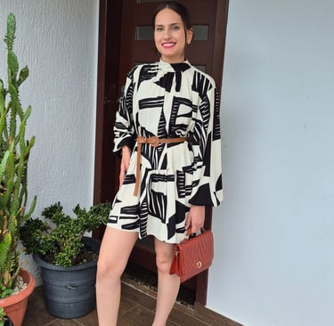 Mulher usando vestido amplo com cinto e usando uma bolsa marrom