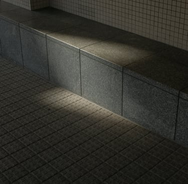 Sunlight casting shadows on a concrete tiled seating area and wall.