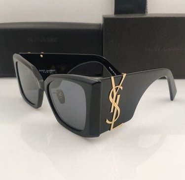 a pair of YSL sunglasses with a black frame and a black box