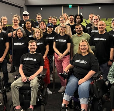 The Microsoft accessibility team in an auditorium, Sean seated at front with other wheelchair users