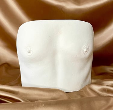 Moulage petite poitrine en plâtre sur fond doré