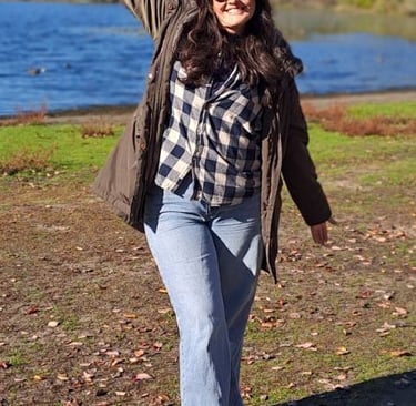 a woman standing in front of a lake