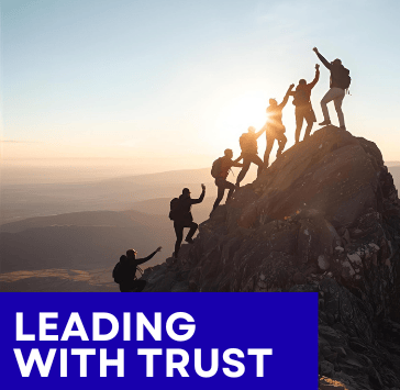 Photo of team  trusting each other to reach mountain peak