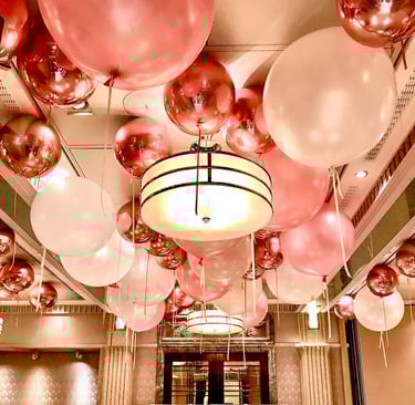 Festive balloon ceiling decor with pastel and metallic balloons for a 1st birthday celebration.