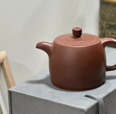 A brown Yixing teapot placed on a gray gift box