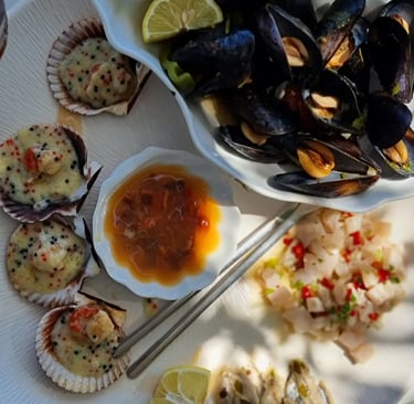 a plate of food with a bowl of food and a glass of wine