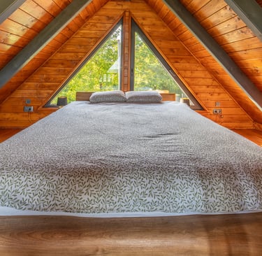 a bed in a loft apartment with a view of the trees