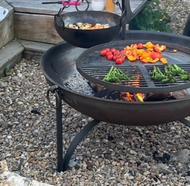 Fire-pit with swing arm BBQ inin a outside seating area as part of outdoor living garden design 